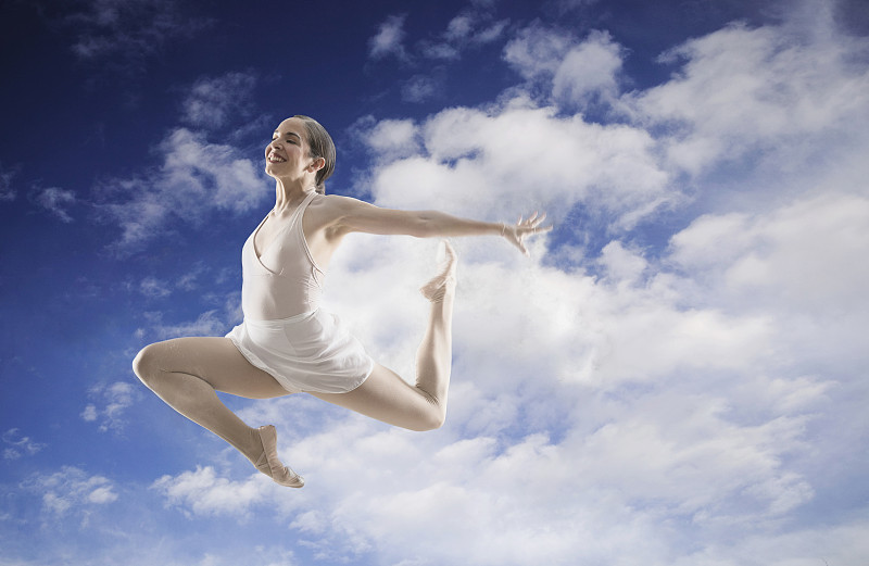 西班牙舞蹈演员在多云的蓝天上跳跃图片下载