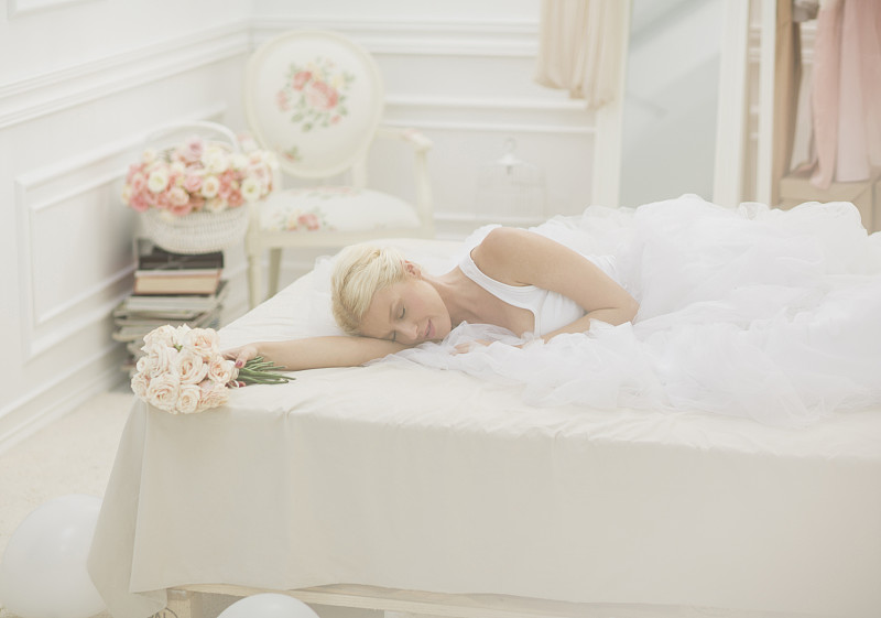 新娘拿着一束花睡在床上图片下载