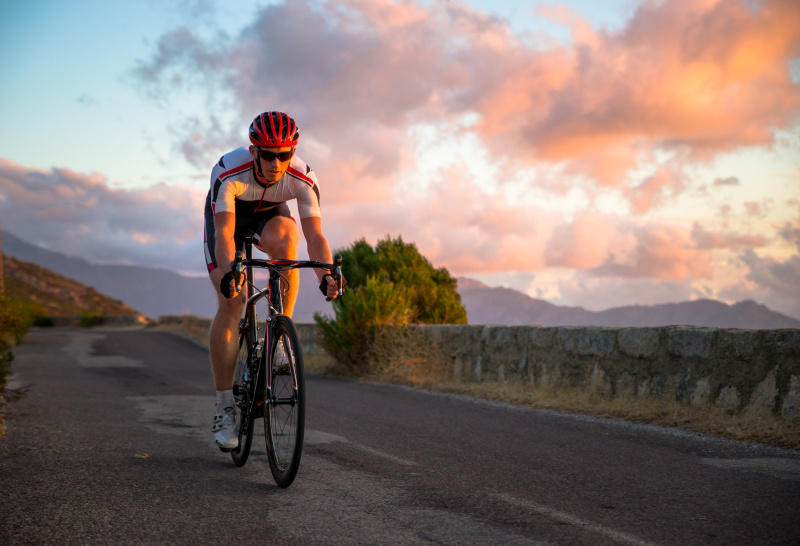 法国科西嘉，夕阳下骑自行车的人图片下载