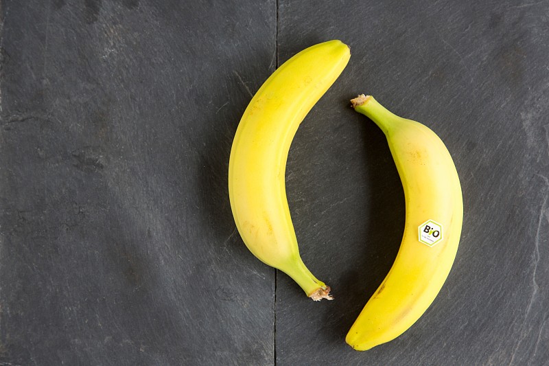 Still life of two bananas - one with bio label图片下载