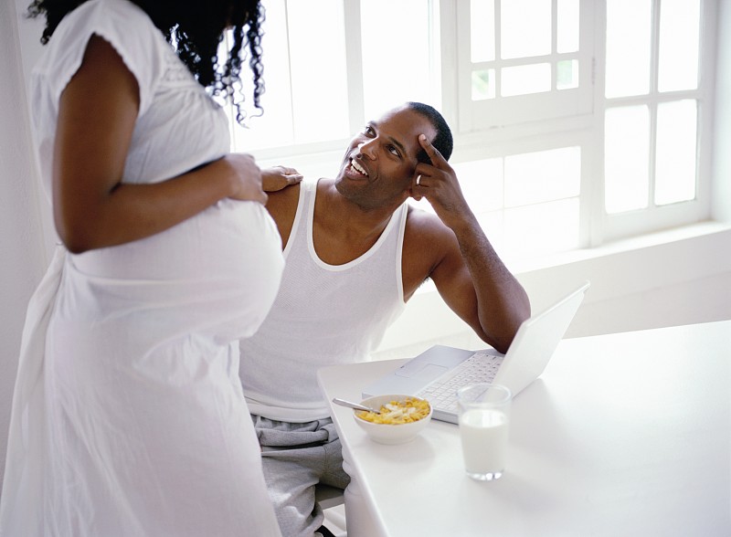 一个孕妇站着和她丈夫说话的侧影图片下载