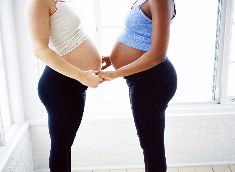 侧面特写的两个孕妇站在对面，手牵手图片下载