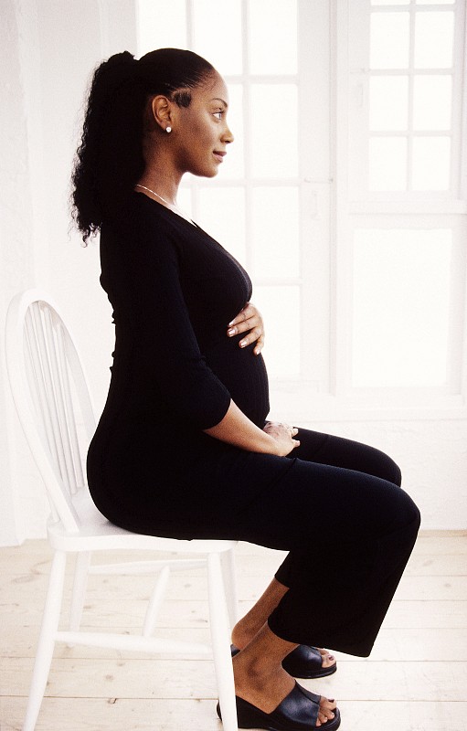 一个孕妇坐在椅子上的侧影图片下载