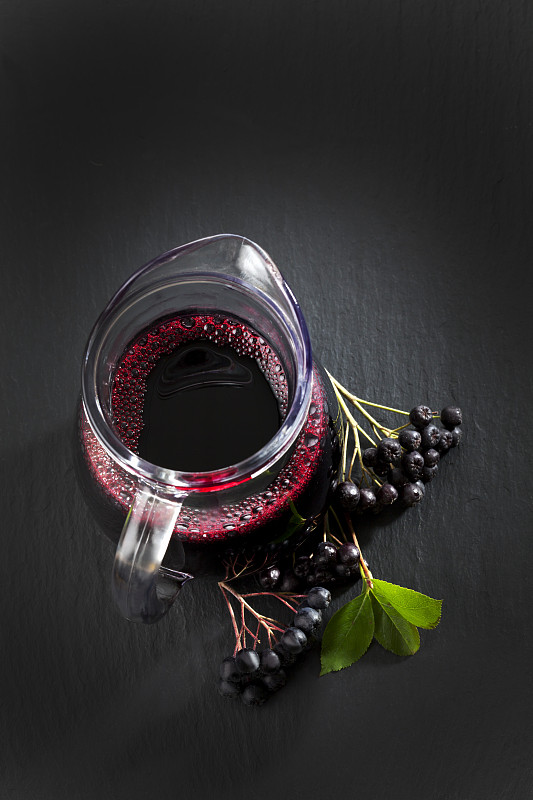 瓶子里的Aronia果汁，石板上的颈莓图片素材