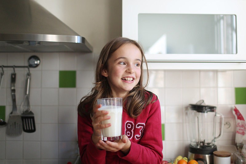 一个10岁的小女孩拿着一杯牛奶图片下载