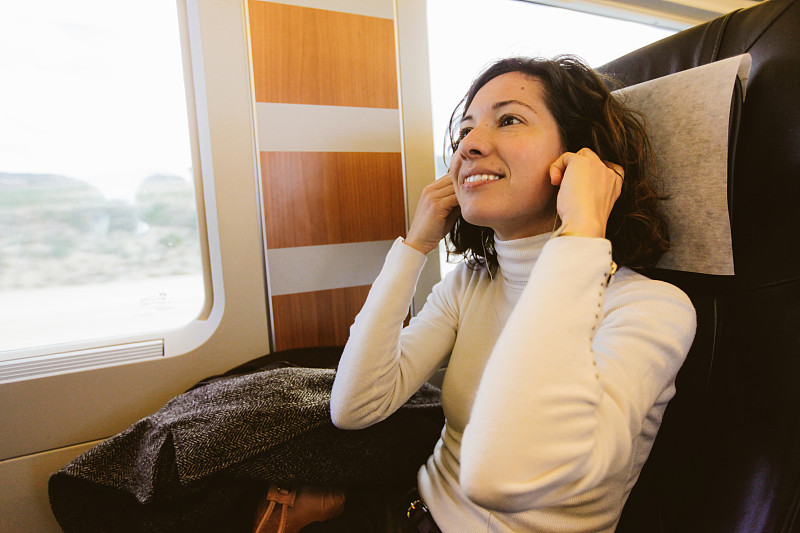 漂亮女人在火车上听耳机图片下载