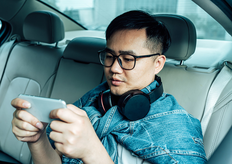 一位年轻男子在车里玩手机游戏图片素材