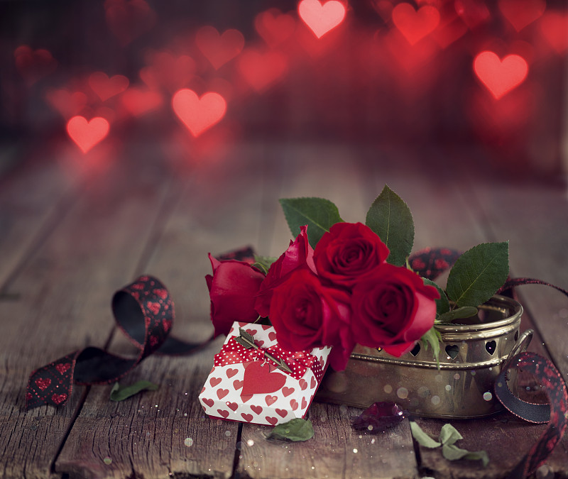 情人节礼物与红玫瑰在黑暗的森林背景图片下载