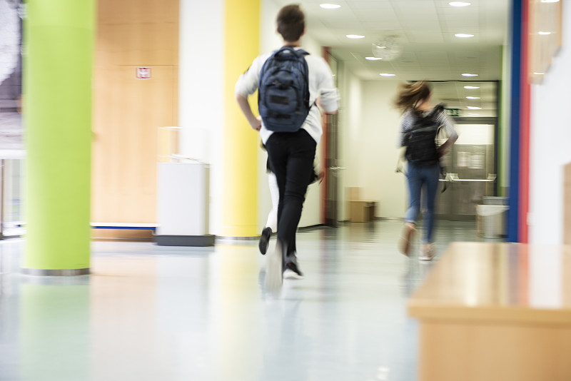 学生们在学校走廊上奔跑。图片下载