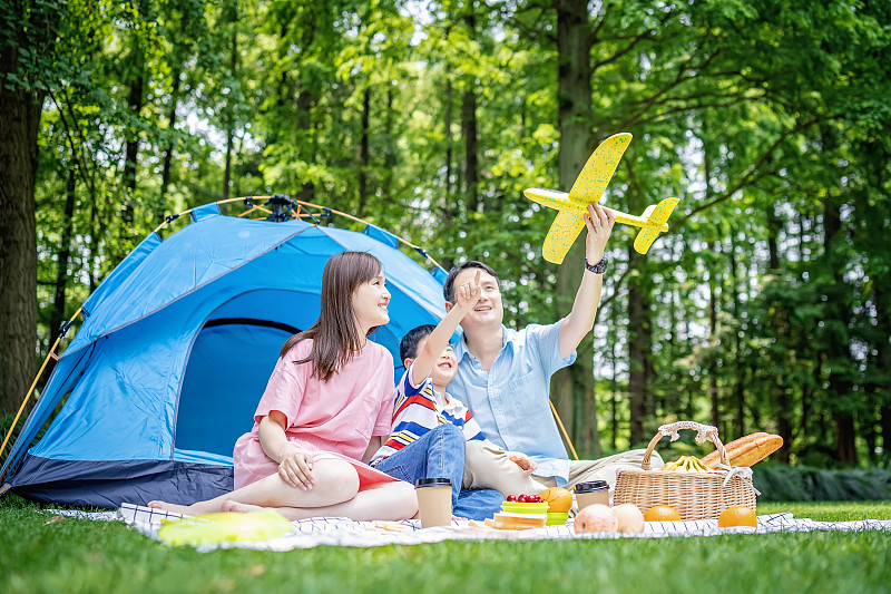 快乐的年轻家庭露营在森林图片素材