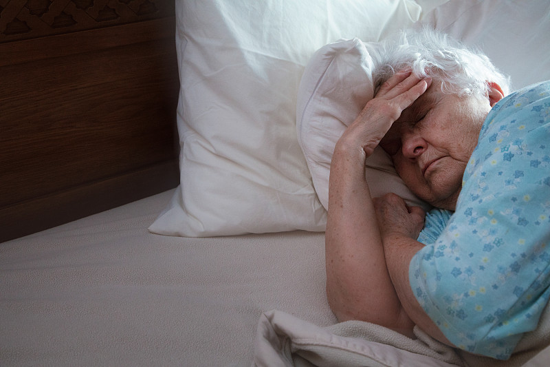 生病的老妇人躺在床上想睡觉图片下载