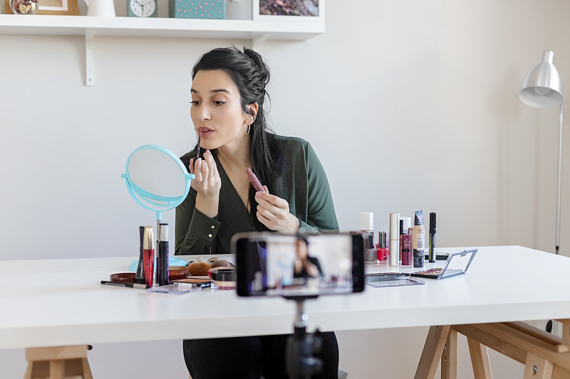 一个女人正在为她的美容产品博客制作视频图片素材