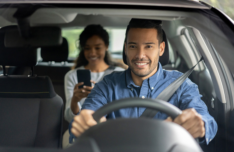 快乐的司机从一个汽车请求服务驾驶一个女人图片素材
