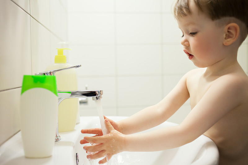 2岁的小男孩在浴室用肥皂洗手图片下载