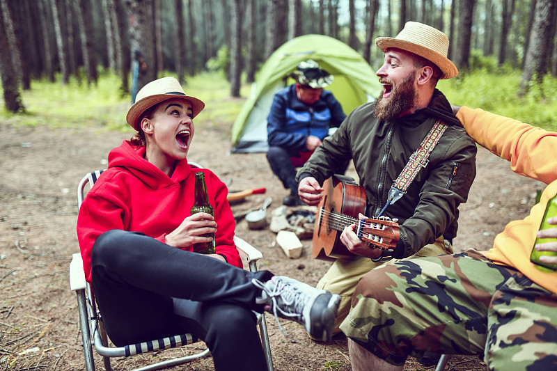 朋友们在野营时一边喝酒一边唱歌图片素材