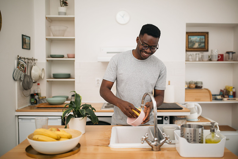 快乐的非裔美国人在家里洗碗图片下载