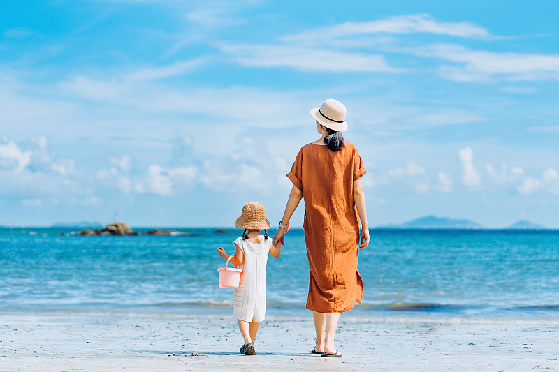 后视图深情年轻的亚洲母亲和小女儿手牵手散步，分享时刻在海滩上漫步在一个阳光明媚的夏天图片下载