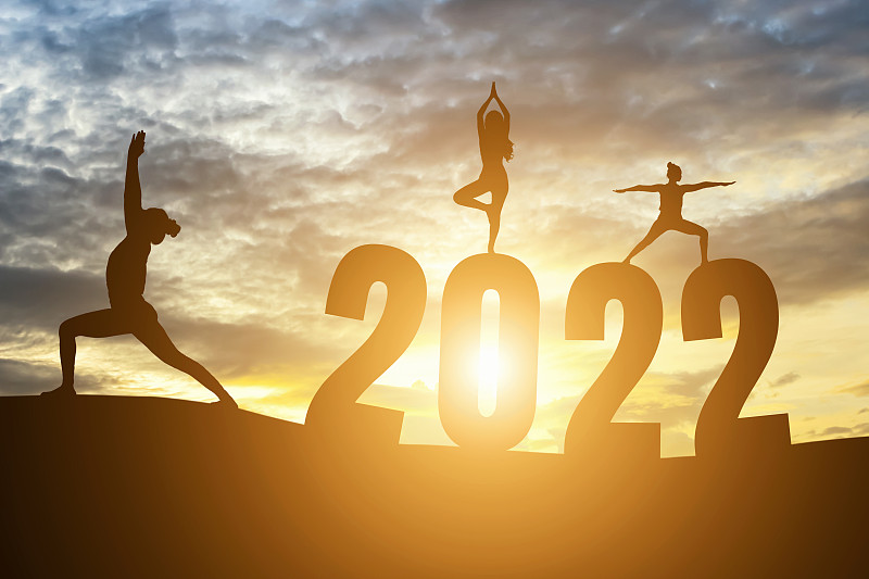 新年快乐数字2022，晨曦中练瑜伽的女子晨曦越过地平线背景，健康和新年快乐的概念。图片下载