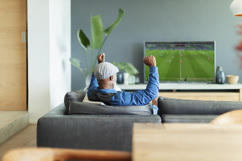 兴奋的男人在客厅里欢呼，看电视上的足球比赛图片下载