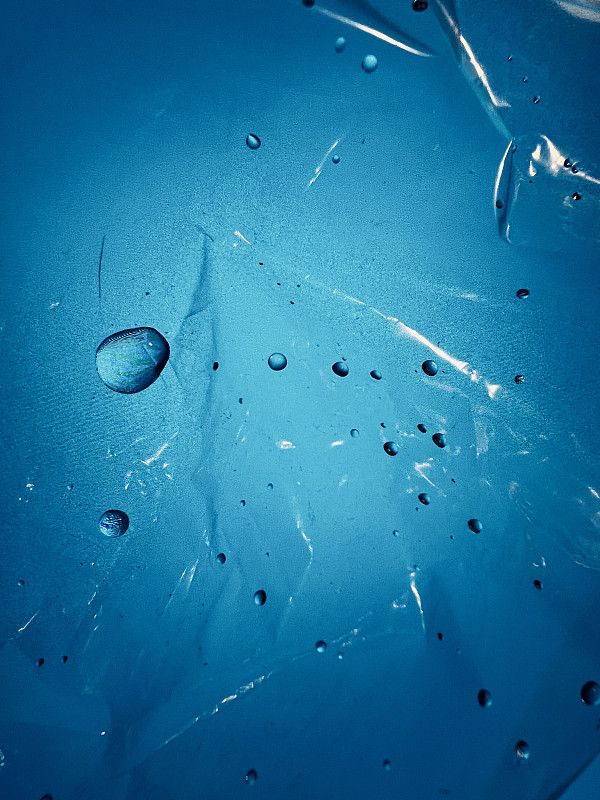 水滴在塑料对蓝色背景摄影图片