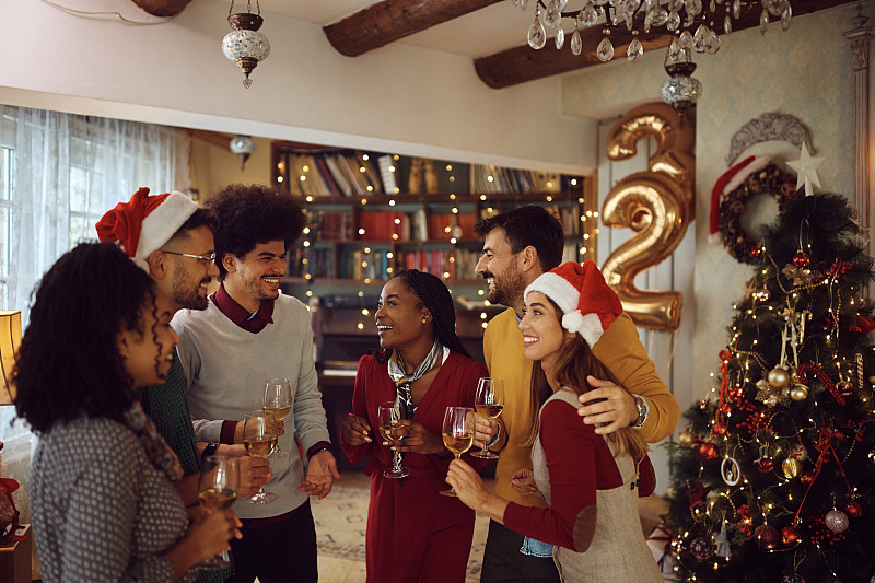 多种族的快乐的人们在庆祝新年的家庭聚会上交谈。图片下载