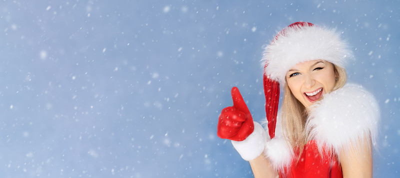 戴着圣诞老人帽子的女人大拇指戴着红色手套图片下载