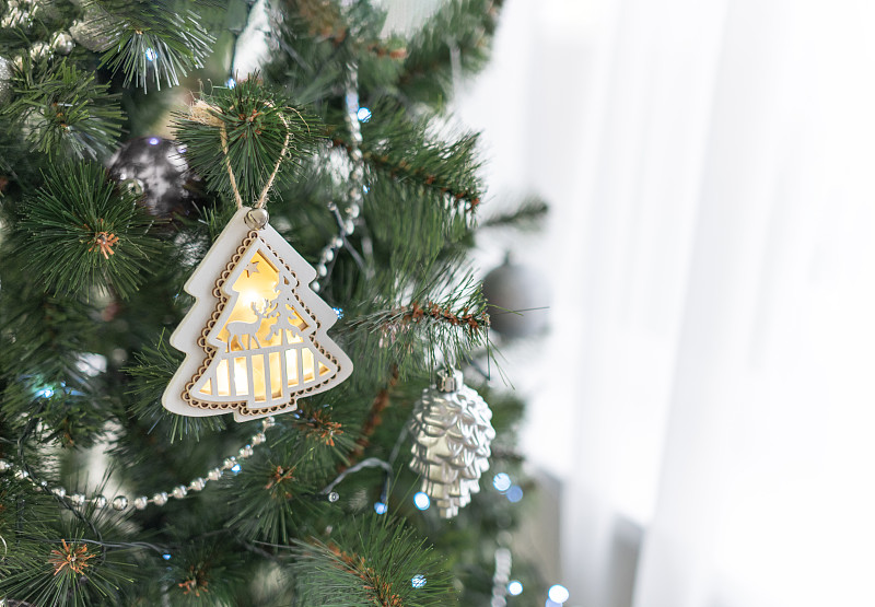 一个木制圣诞树玩具，在圣诞树上发光，为新年和圣诞节一个舒适的装饰。图片下载