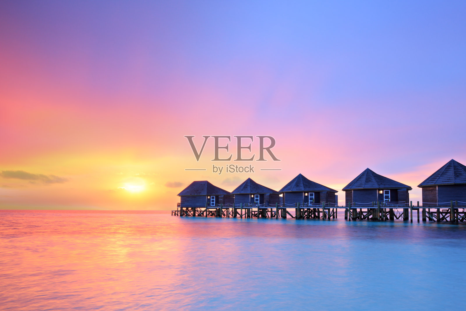 日落马尔代夫岛，水上别墅度假胜地照片摄影图片