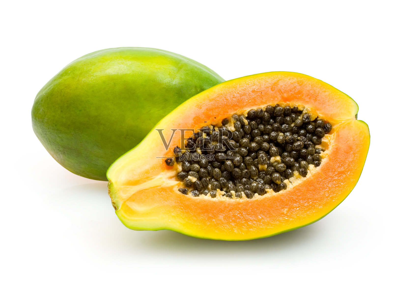 一半的木瓜显示橙色的果肉和深色的种子绿色的皮照片摄影图片