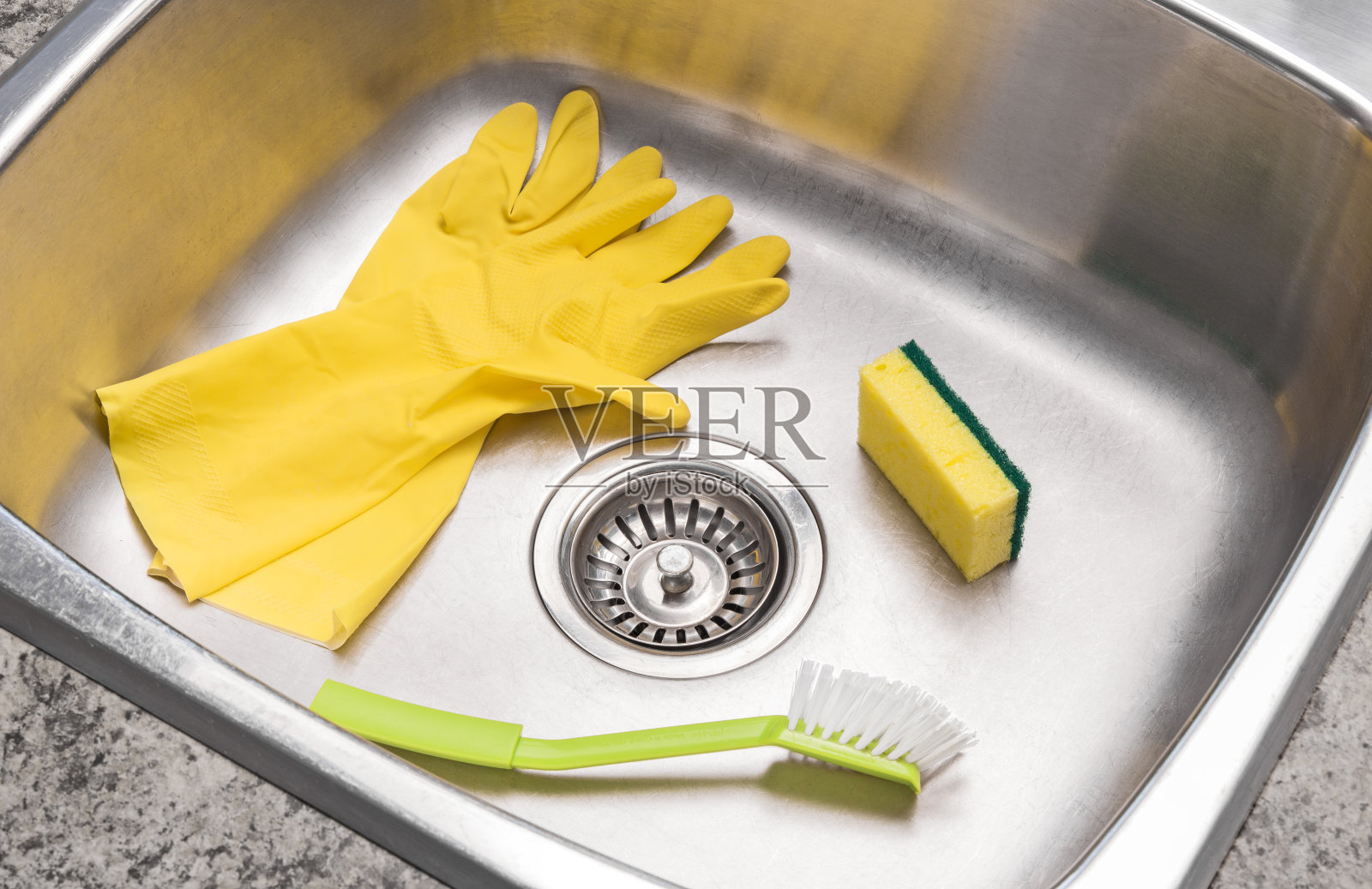 把手套、海绵和刷子放在干净的厨房水槽里照片摄影图片