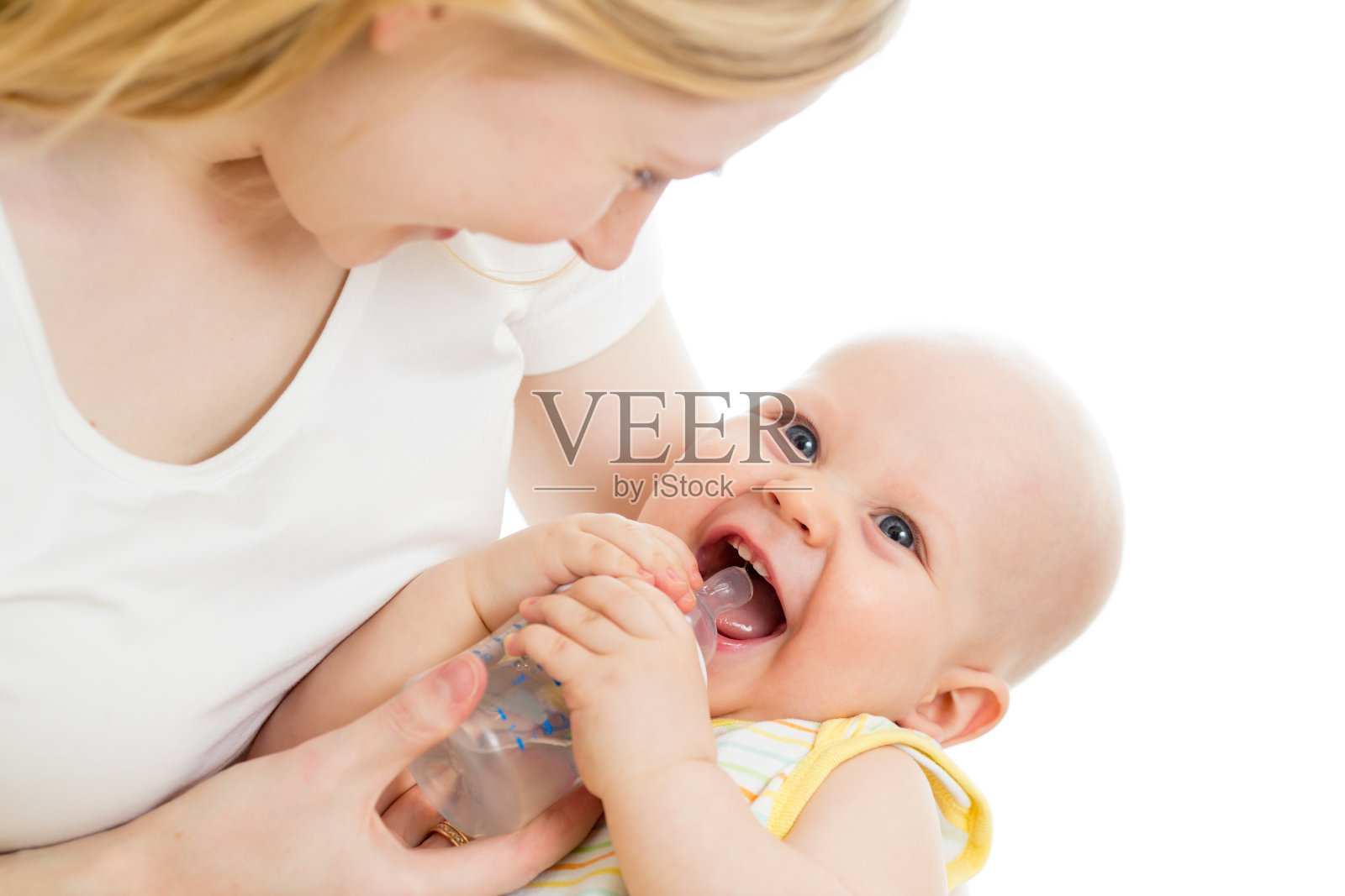 慈爱的母亲用奶瓶喂养她可爱的儿子照片摄影图片