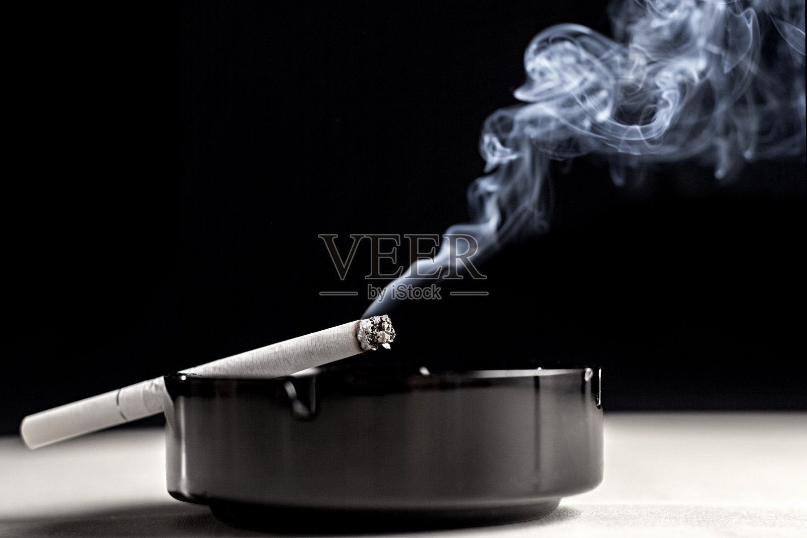 烟灰缸里的香烟和烟雾照片摄影图片