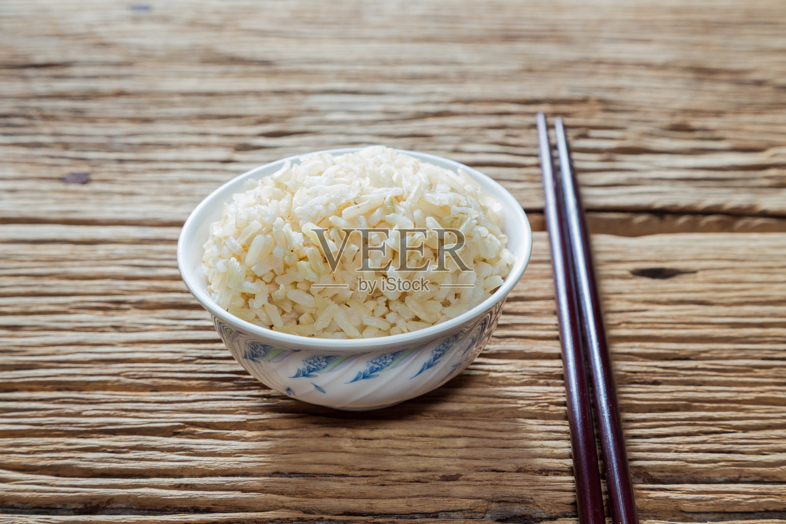 用筷子夹一碗糙米照片摄影图片
