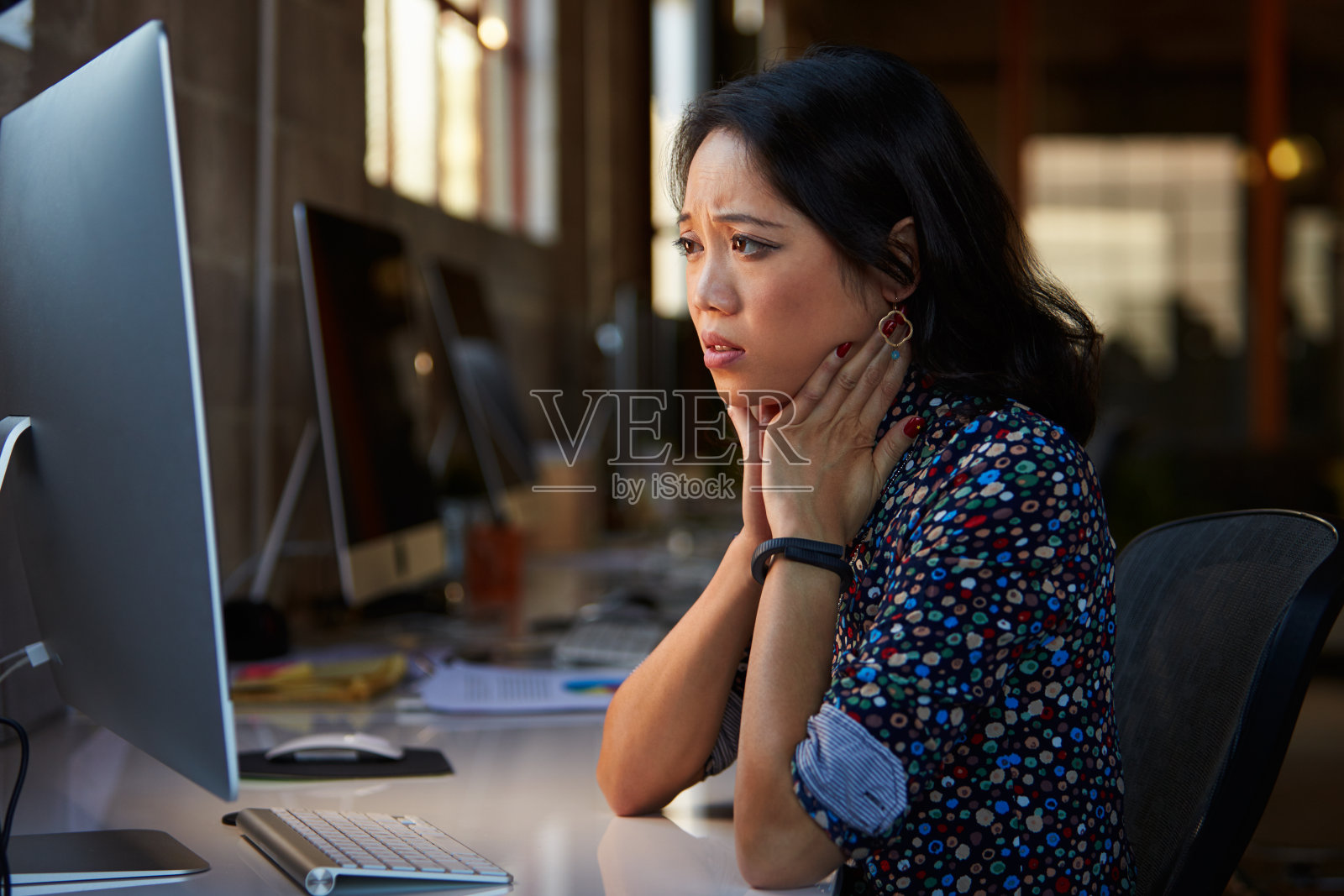 压力大的女性设计师在现代办公室的电脑前工作照片摄影图片