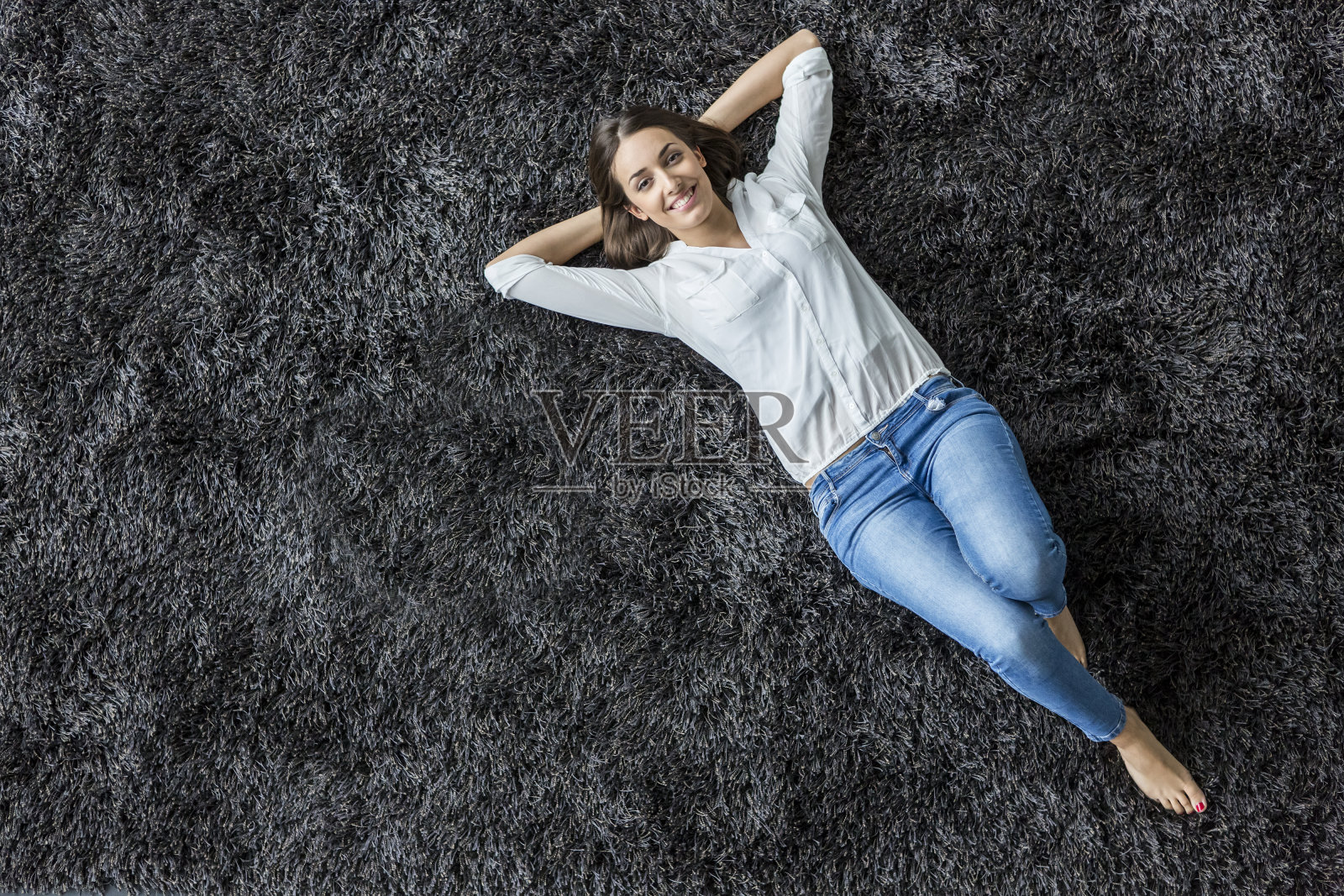 年轻女子躺在地毯上照片摄影图片