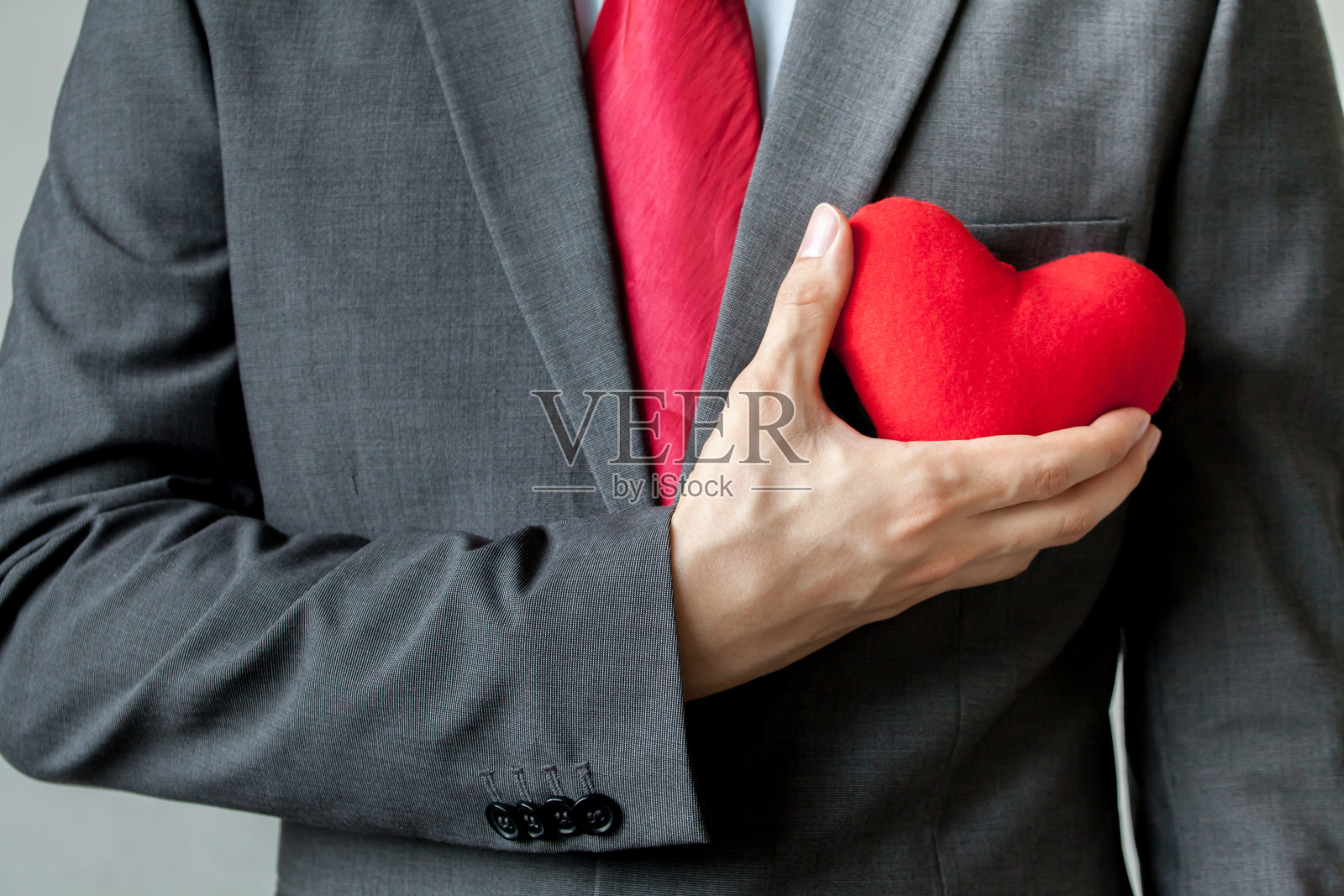 商人胸中抱着一颗红心表示同情照片摄影图片