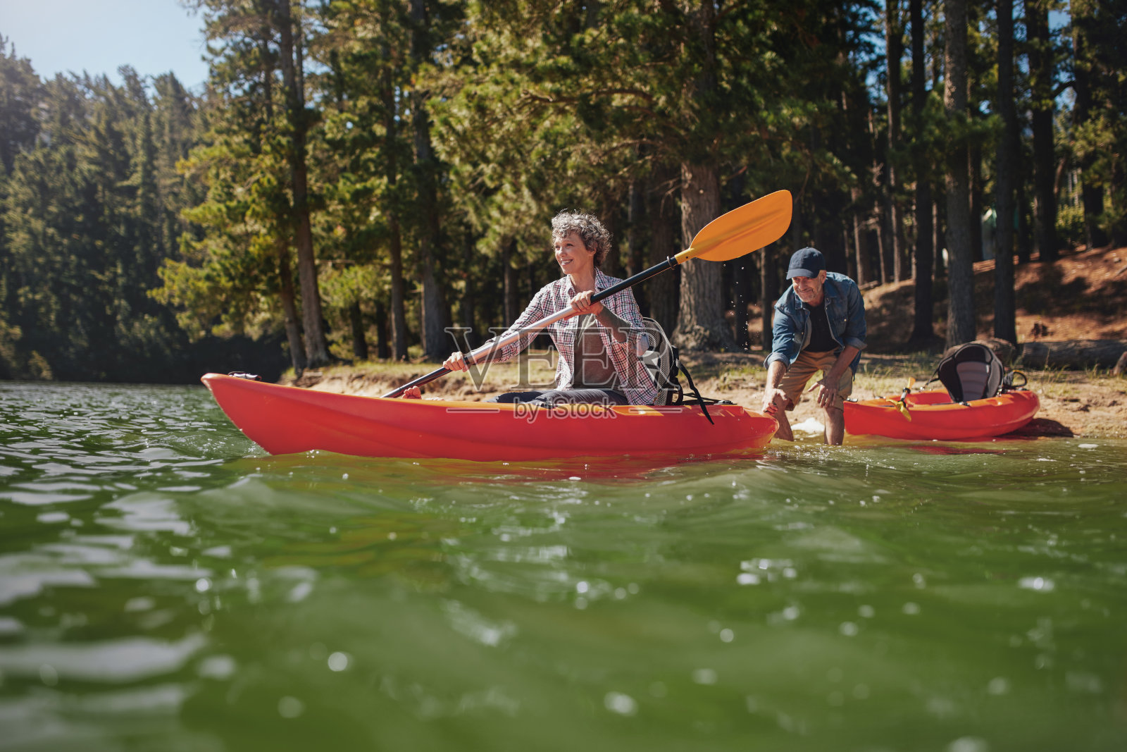 一对成熟的夫妇在湖里玩皮划艇照片摄影图片