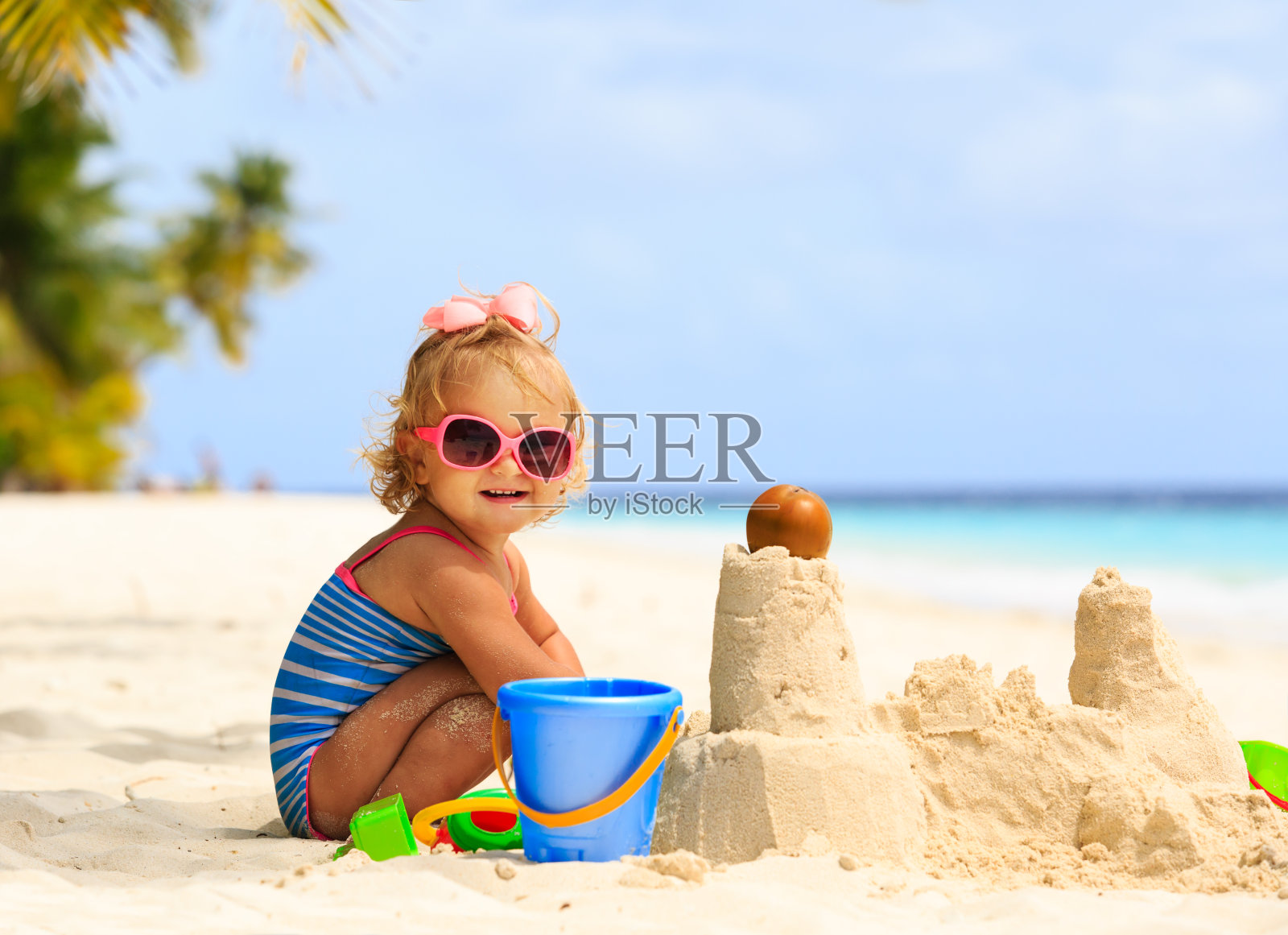 可爱的小女孩在沙滩上玩沙子照片摄影图片