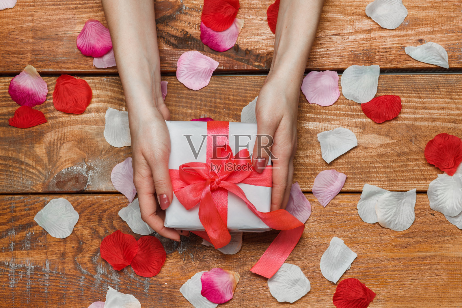 情人节的礼物和女性手放在木制的背景上照片摄影图片