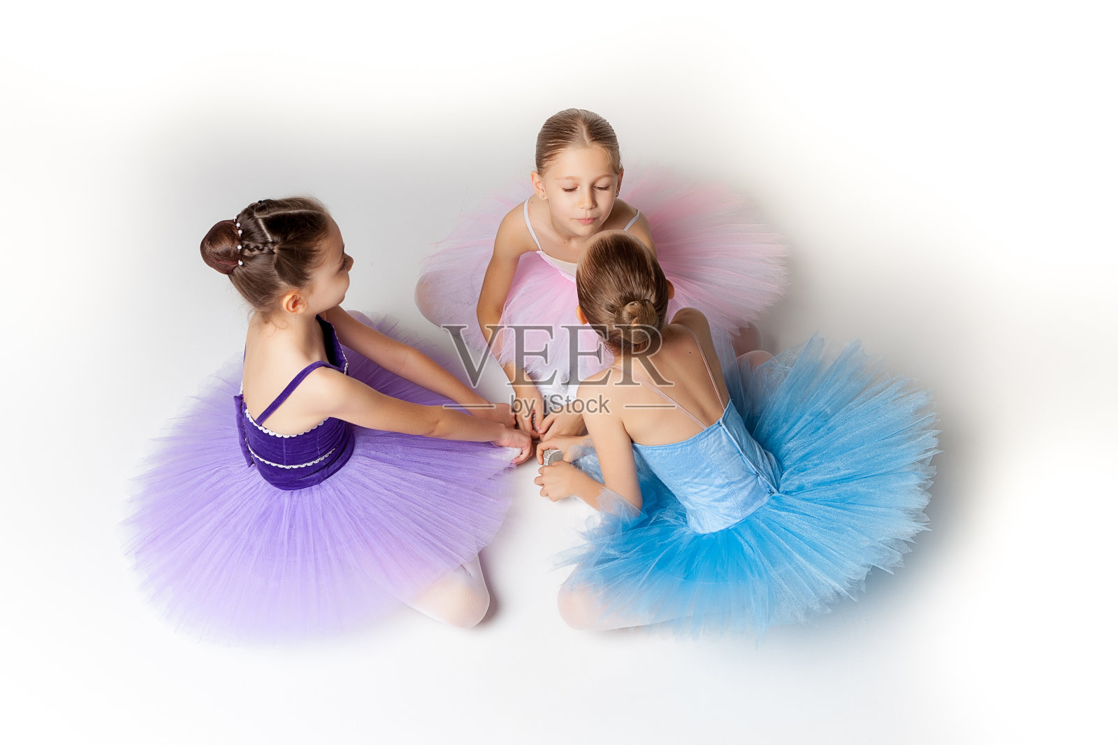 三个芭蕾舞小女孩穿着芭蕾舞裙坐在一起摆姿势照片摄影图片