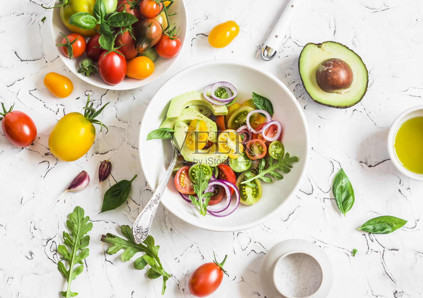 新鲜的沙拉，西红柿和牛油果在一个明亮的背景照片摄影图片