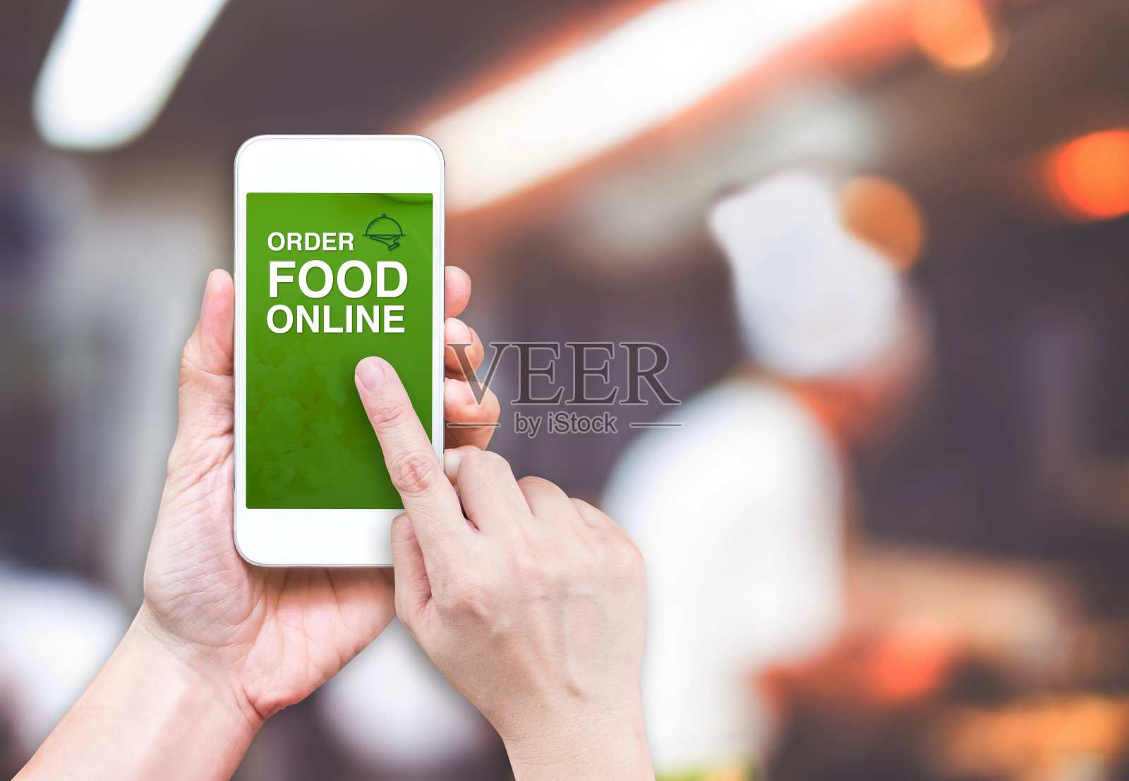 手握手机与在线订购食物模糊餐厅照片摄影图片