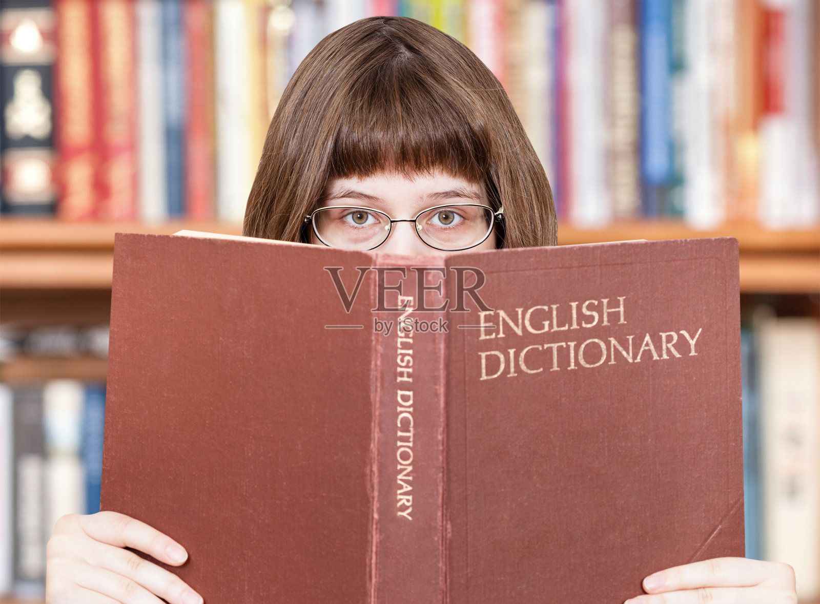 这个女孩在看英语词典和书照片摄影图片