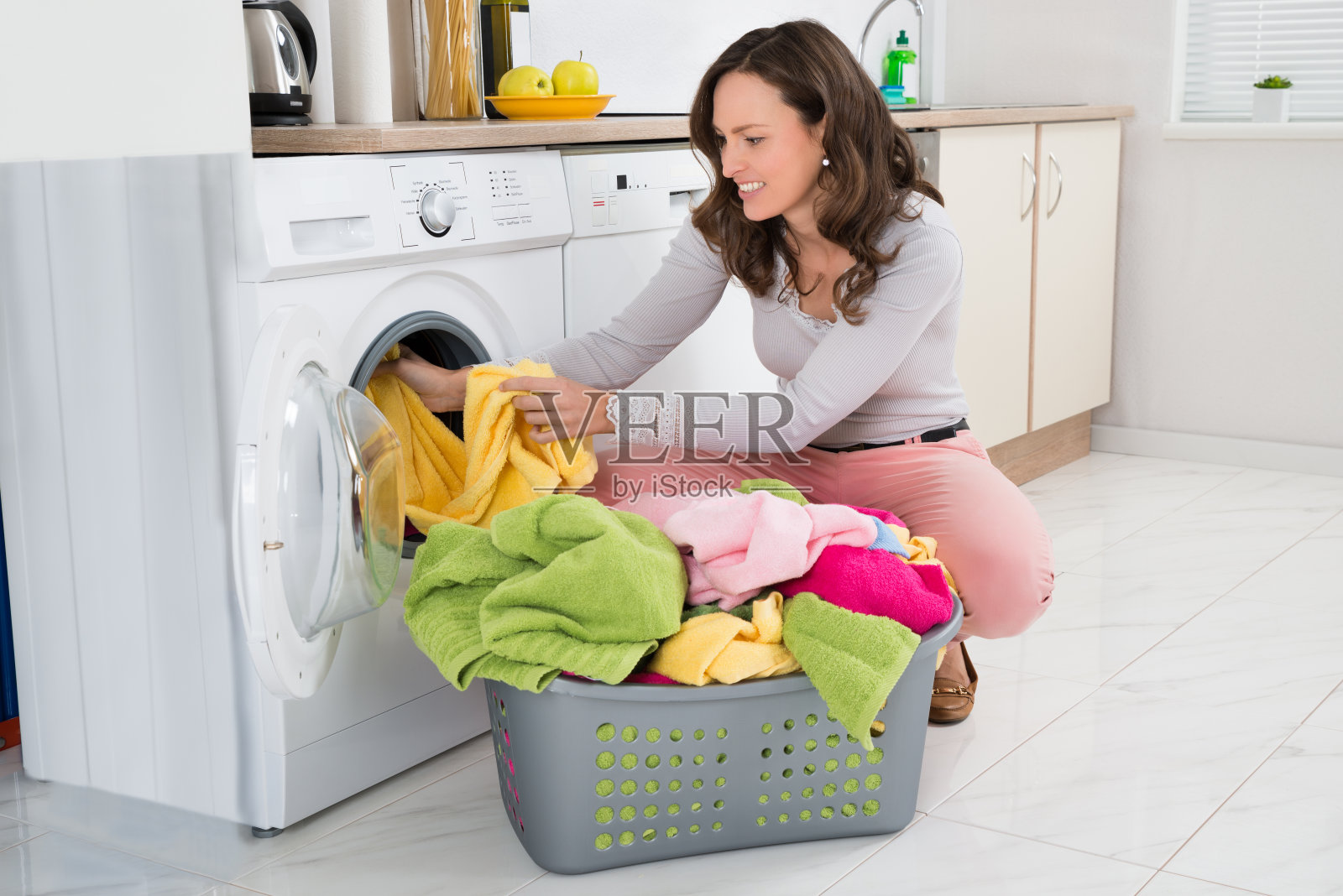 女人把衣服放进洗衣机照片摄影图片