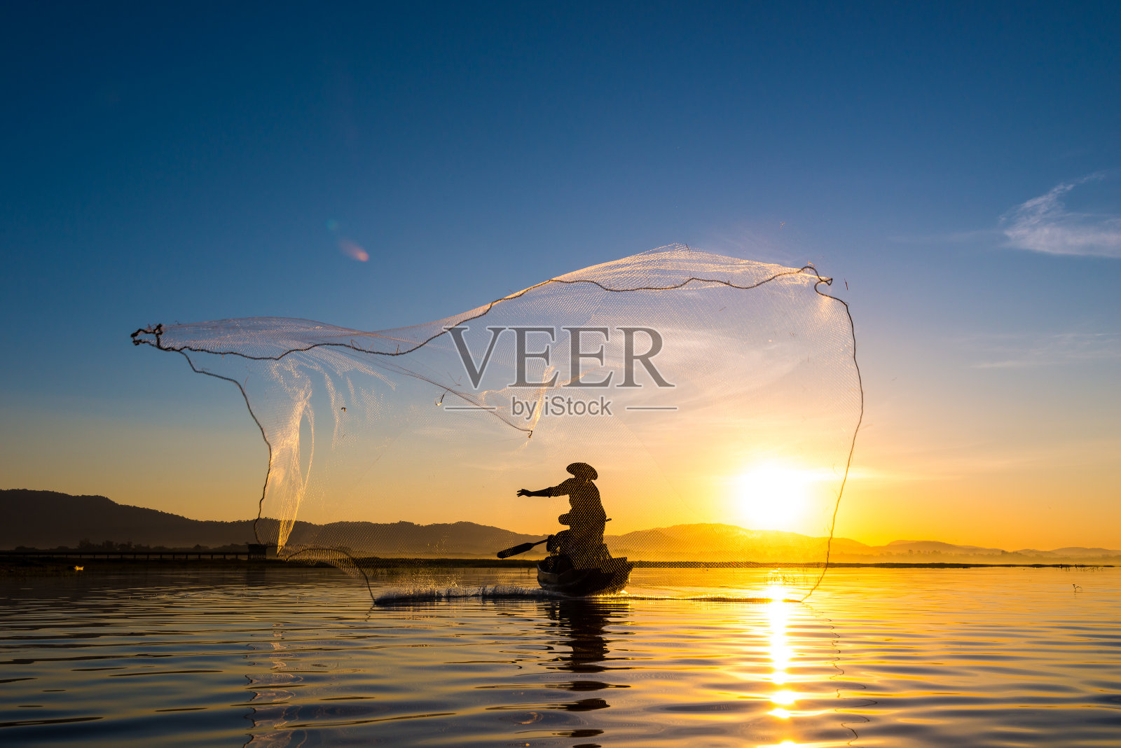 早上钓鱼时渔夫在行动照片摄影图片