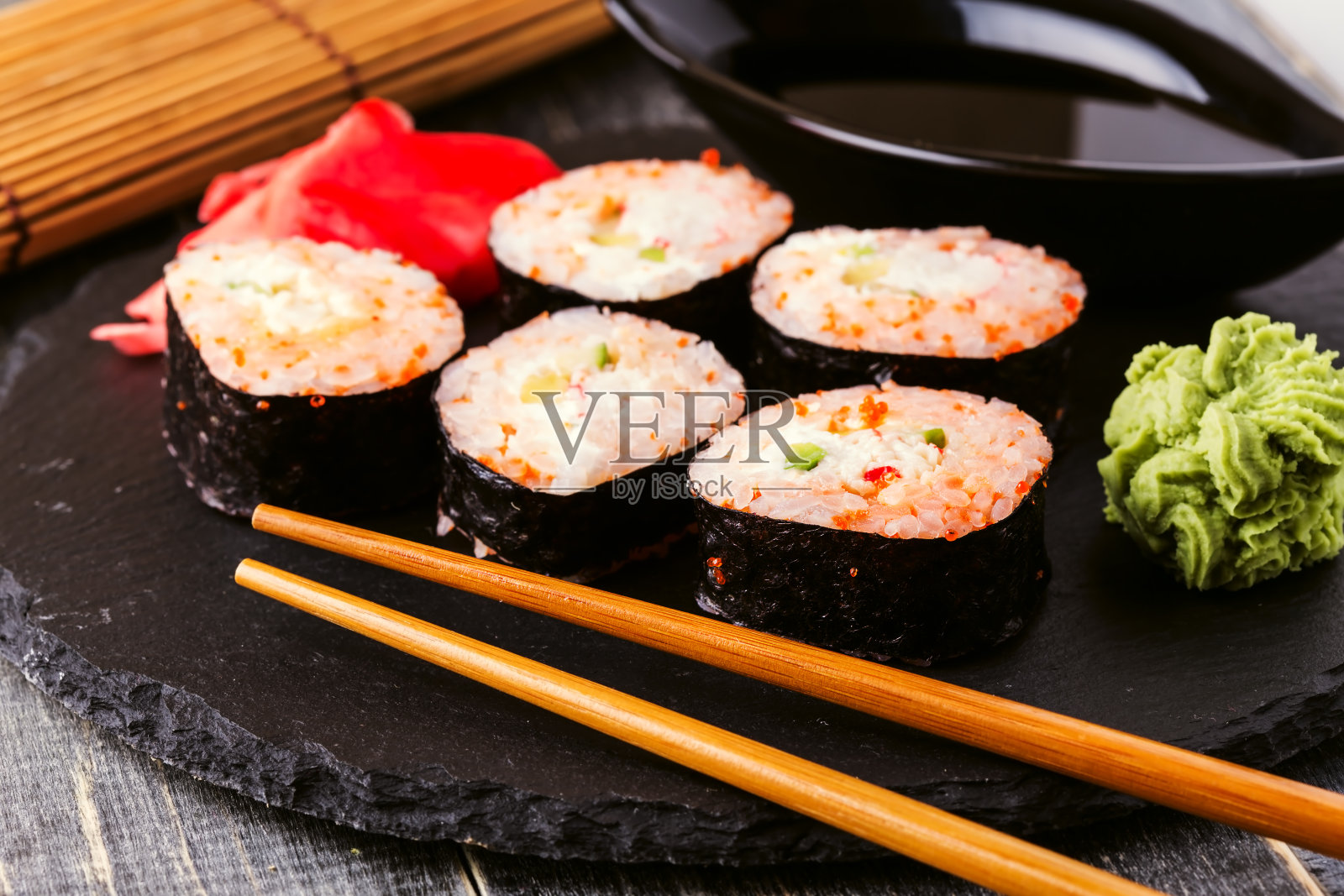 寿司卷配蟹肉、辣酱、黄瓜和鱼子酱。照片摄影图片
