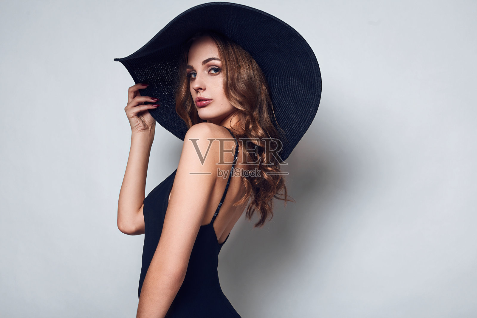 优雅美丽的女人穿着黑色的衣服和帽子照片摄影图片