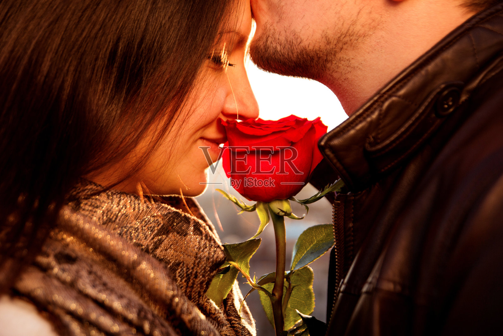 多情的小伙子用红玫瑰轻轻吻着他的女孩照片摄影图片