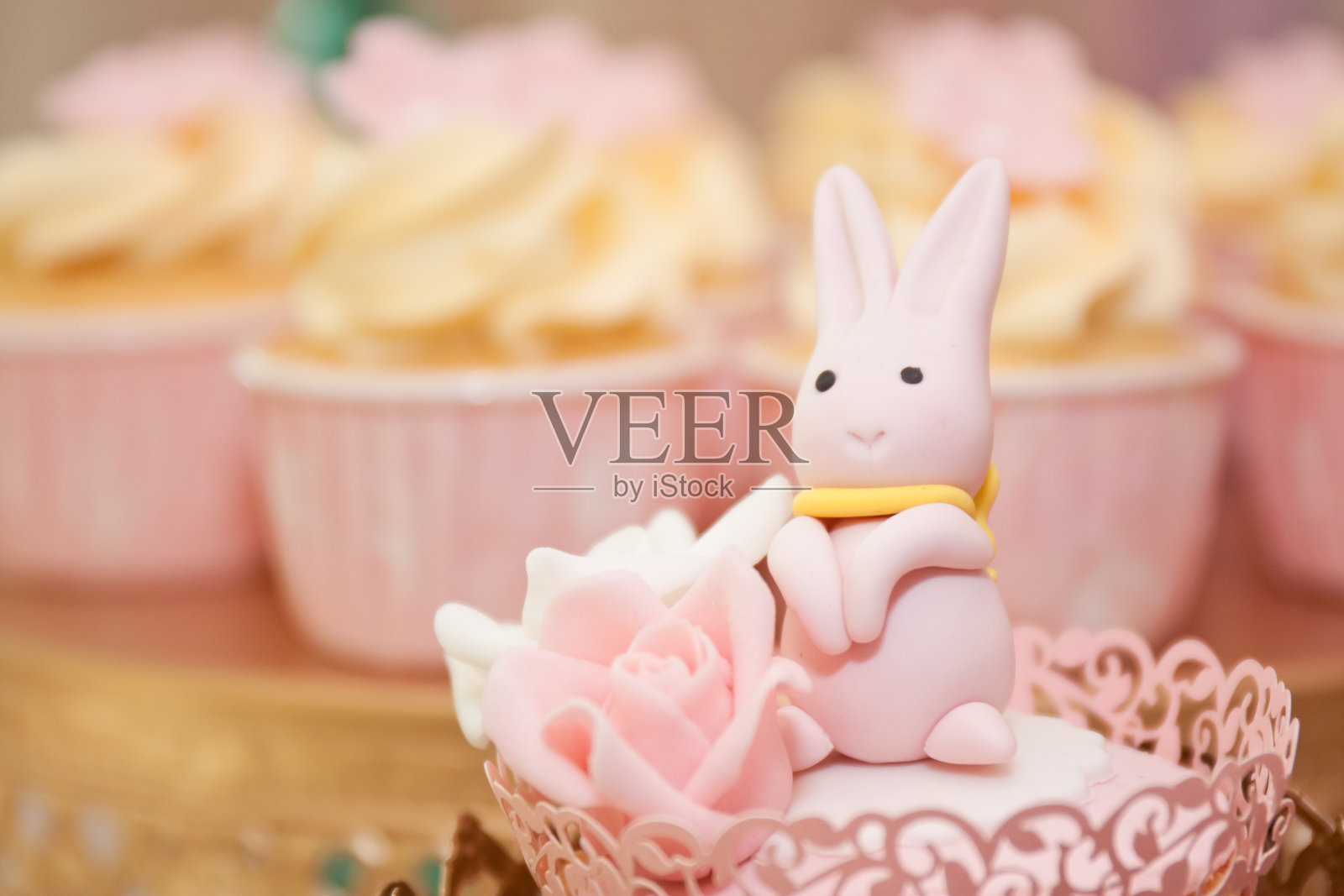 可爱的翻糖兔子坐在纸杯蛋糕上照片摄影图片