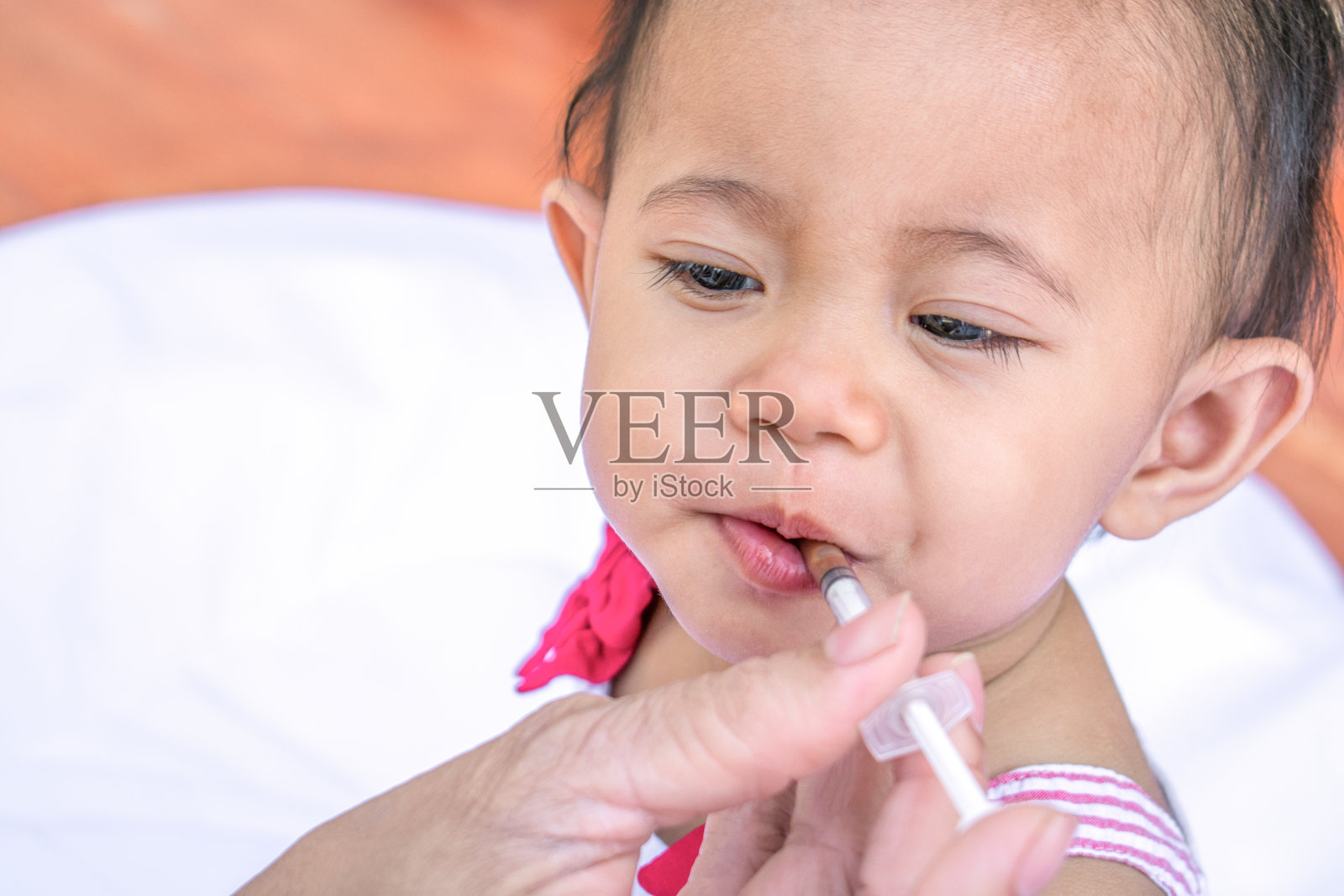 用注射器给婴儿喂药水照片摄影图片